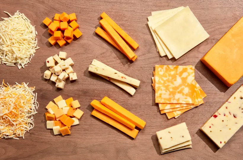 cheese displayed in different ways, grated, cubes, sticks, slices