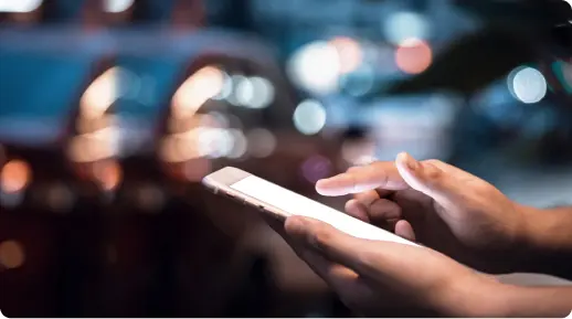 a blurry background with a foreground of hands holding a phone