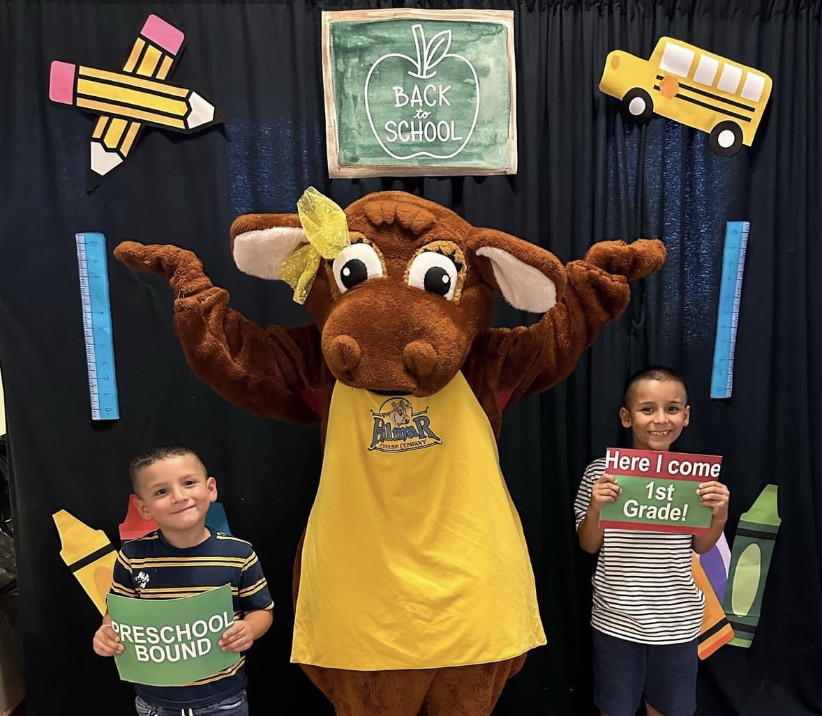 boy and girl holding grade level signs with Daisy the cow