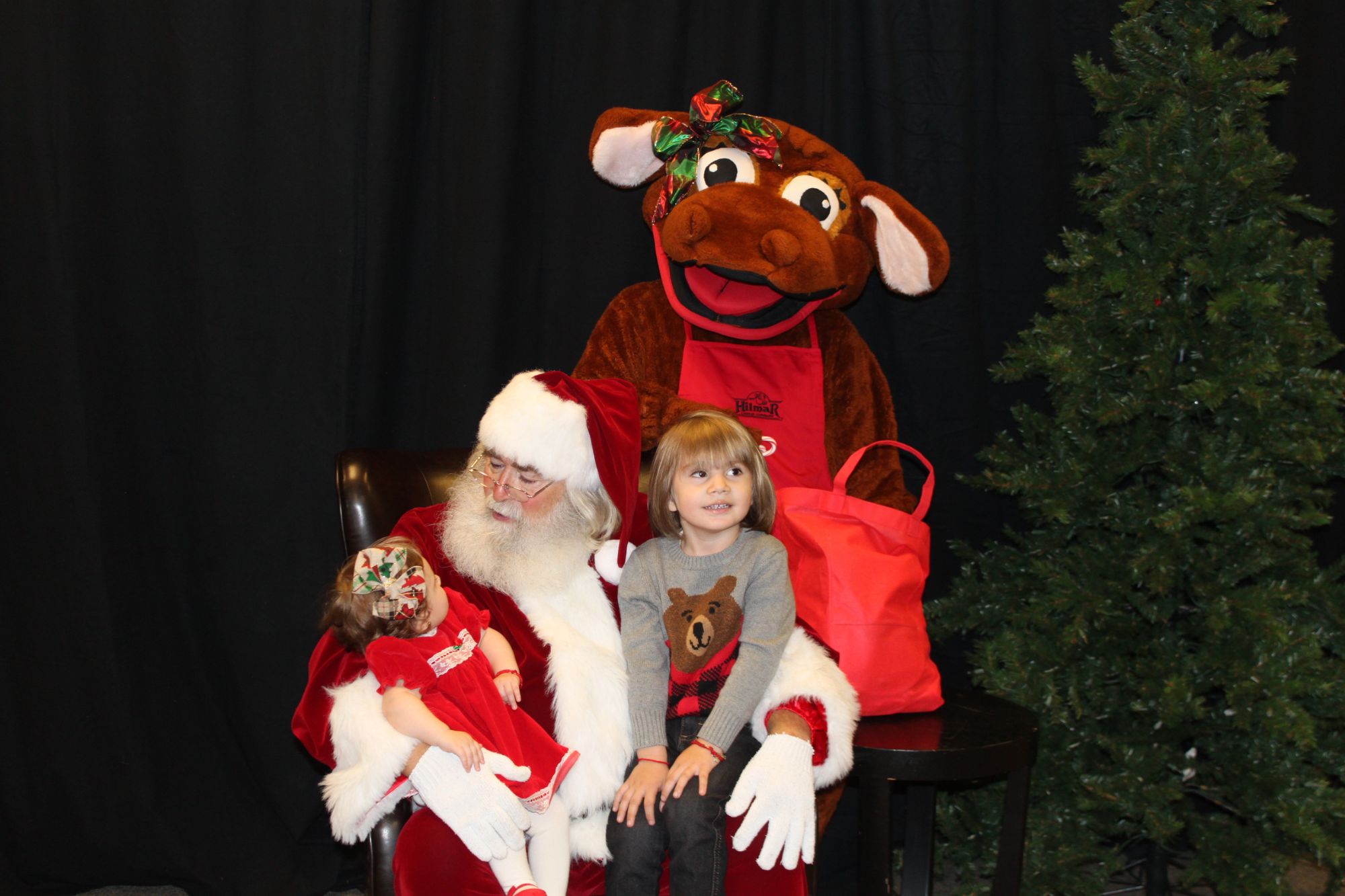 Santa, Daisy and two children pose for photo