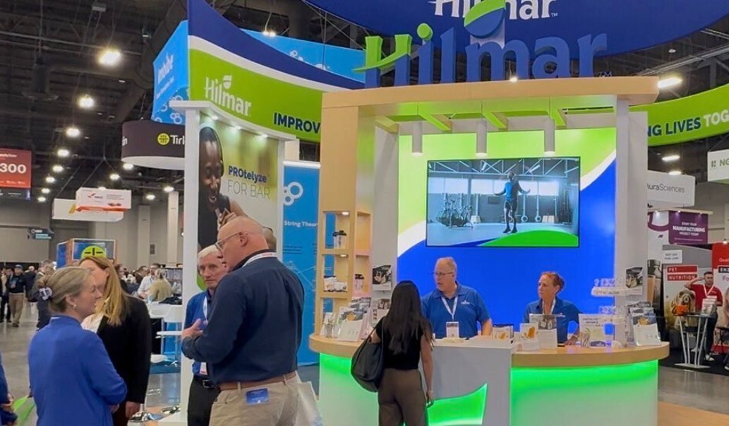 Hilmar employees engage with prospective customers in Hilmar's booth at a trade show